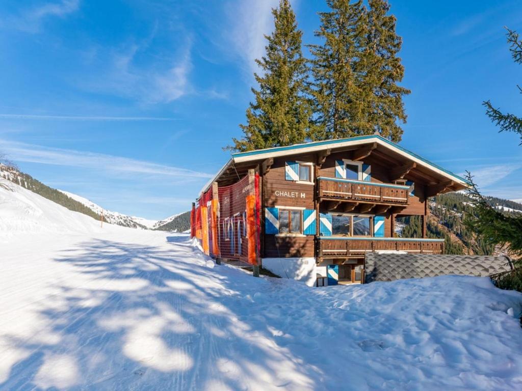 a log cabin in the snow with a long driveway at Chalet H Königsleiten in Königsleiten