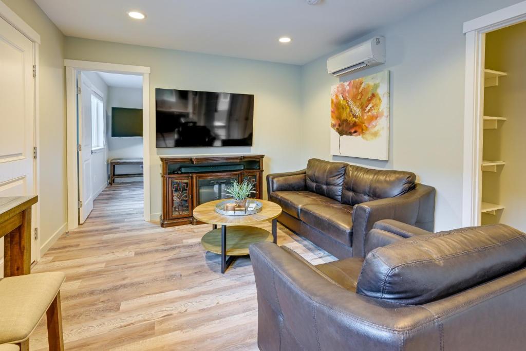 a living room with two leather couches and a tv at Modern SeaTac Gem with Fireplace and Smart TVs! in SeaTac