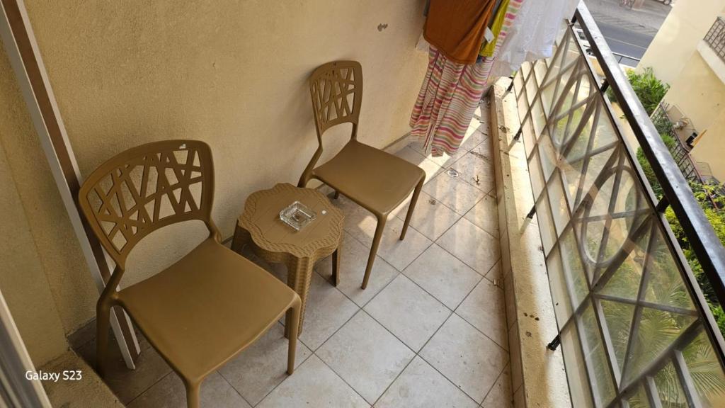 two chairs and a table on a balcony at Ruby Star Hostel Dubai for Male- 4 R- 4 in Dubai