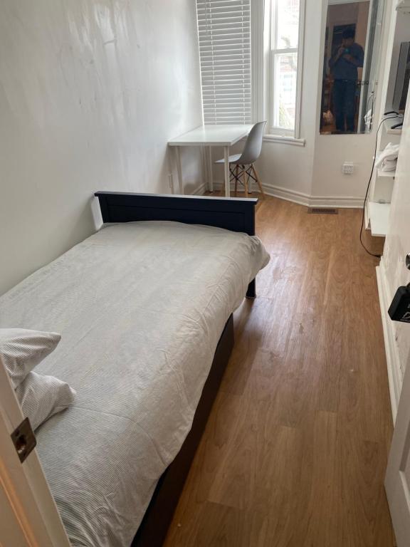 Private Single Room with Shared Bathroom 536C في تورونتو: غرفة نوم بسرير ومكتب في غرفة