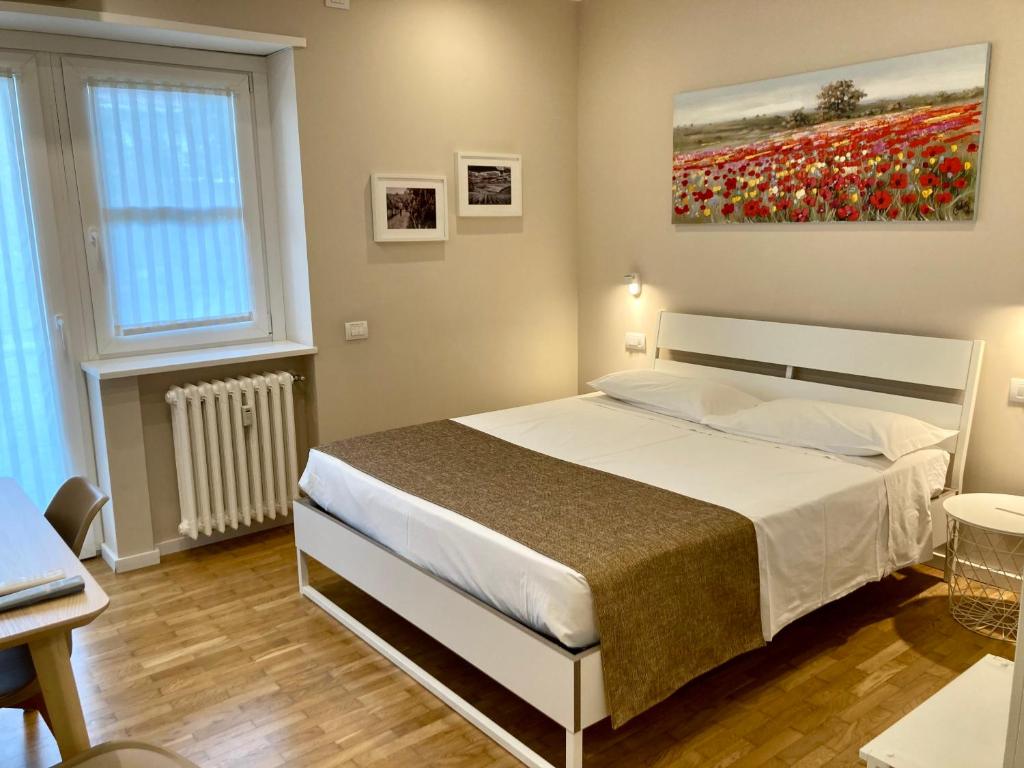 een slaapkamer met een bed en een schilderij aan de muur bij Maison Altinia in Treviso