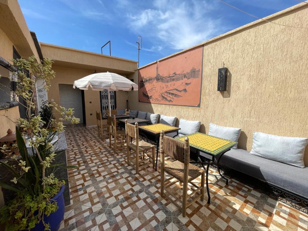 un patio con tavoli, sedie e divano di Sun Hostel a Marrakech
