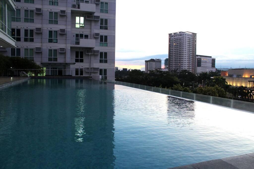 a large swimming pool in the middle of a building at Abreeza 1BR condo w/ balcony,wifi & Netflix in Davao City