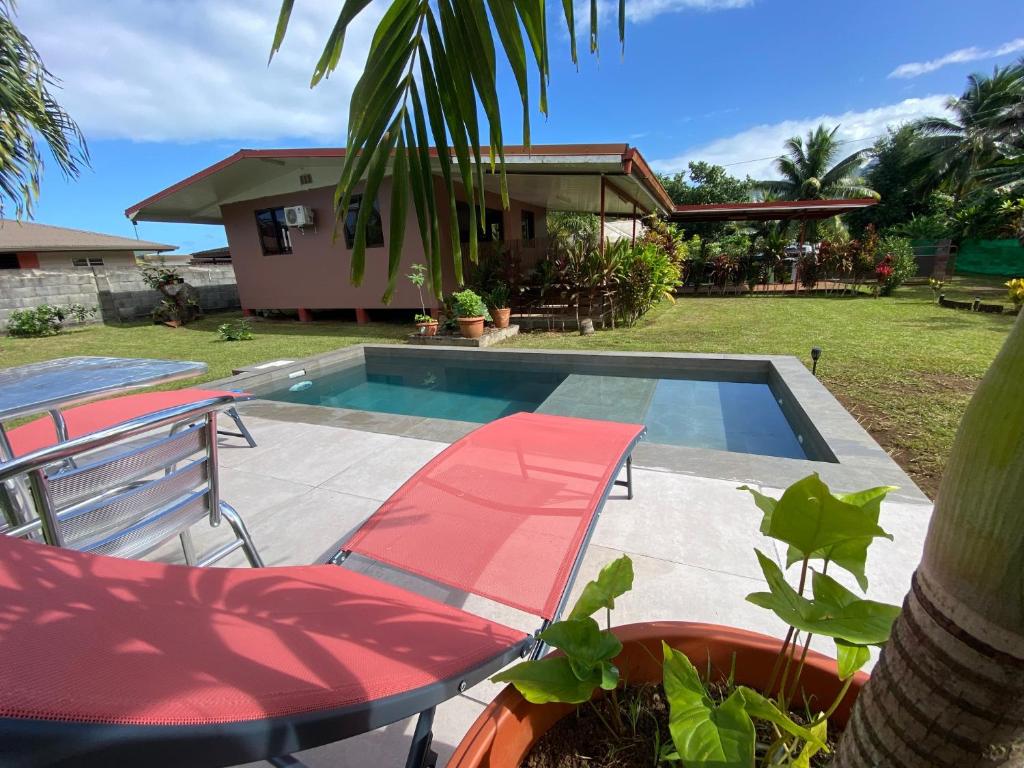 un patio con mesa y sillas y una piscina en TAHITI - Bungalow Toah Hoe, en Taravao