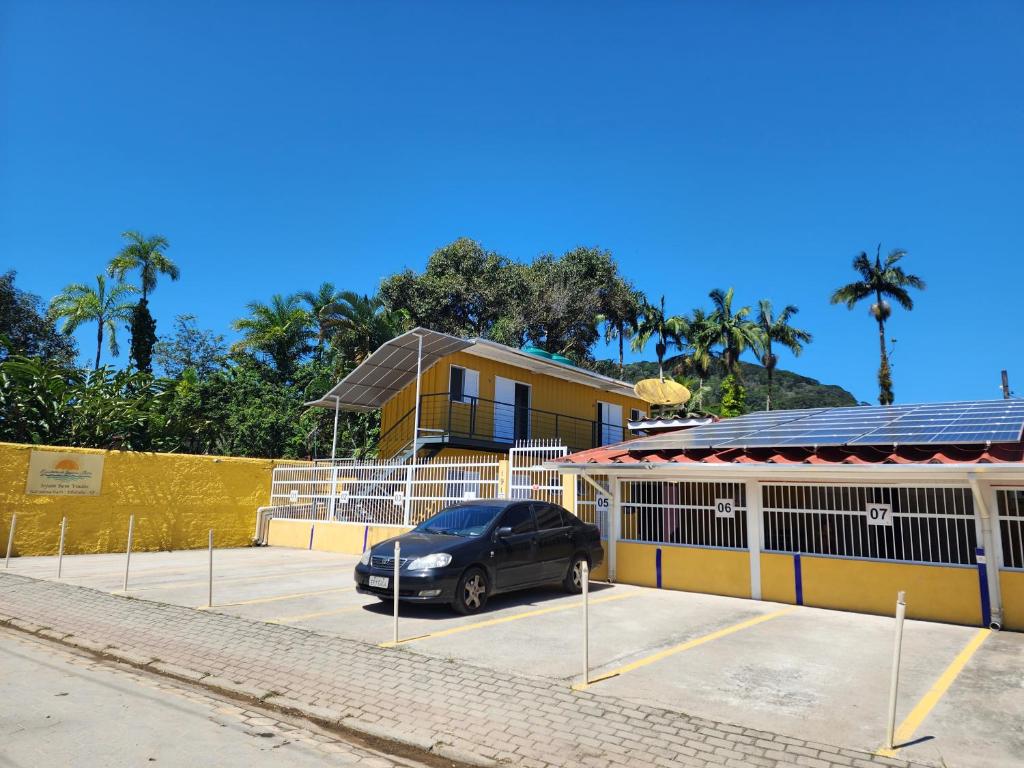 una furgoneta estacionada en un estacionamiento frente a un edificio en Encantos do Lázaro en Ubatuba