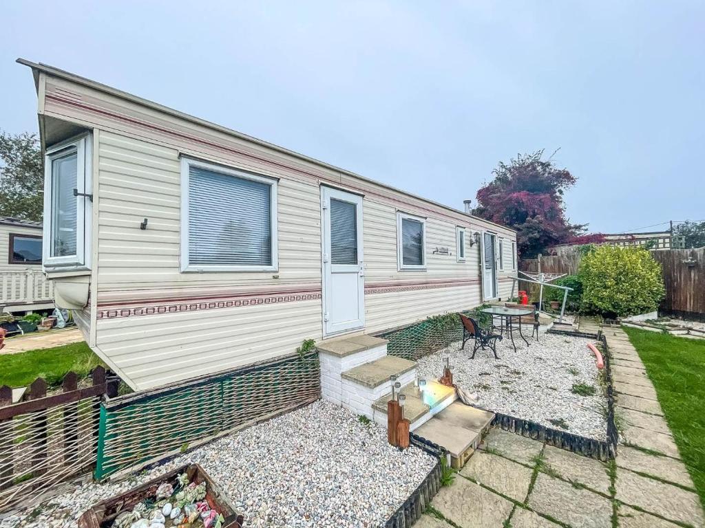 a tiny house with a garden in front of it at Homely Caravan Just A Short Walk To Hembsy Beach In Norfolk Ref 00036ba in Hemsby