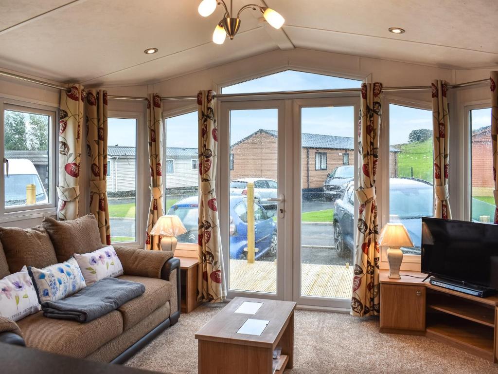 a living room with a couch and a tv at Ashness - Uk44966 in Plumbland