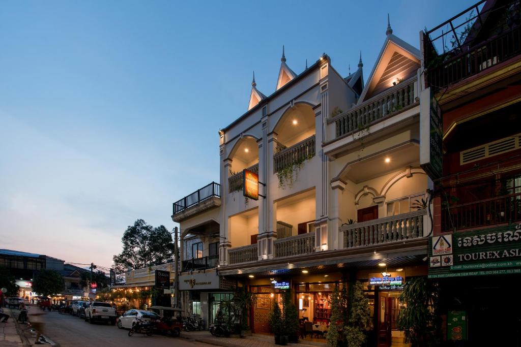 a white building with balconies on a city street at Siem Reap City Angkor Boutique in Siem Reap