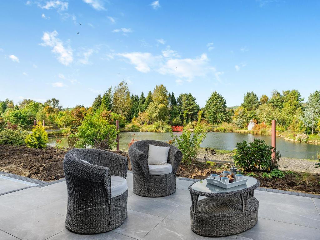 2 sillas y una mesa en un patio con un lago en Lakeside Cottage, en Lanchester