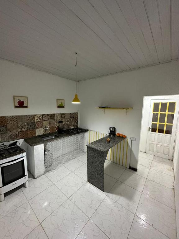 eine große Küche mit Herd und Arbeitsplatte in der Unterkunft Centro Apartamento Búzios in Búzios