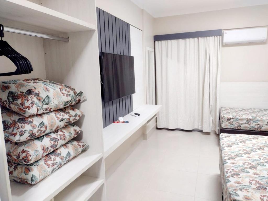 um pequeno quarto com uma cama e uma janela em APARTAMENTO SPAZZIO DI ROMA com acesso ao acqua park splash em Caldas Novas