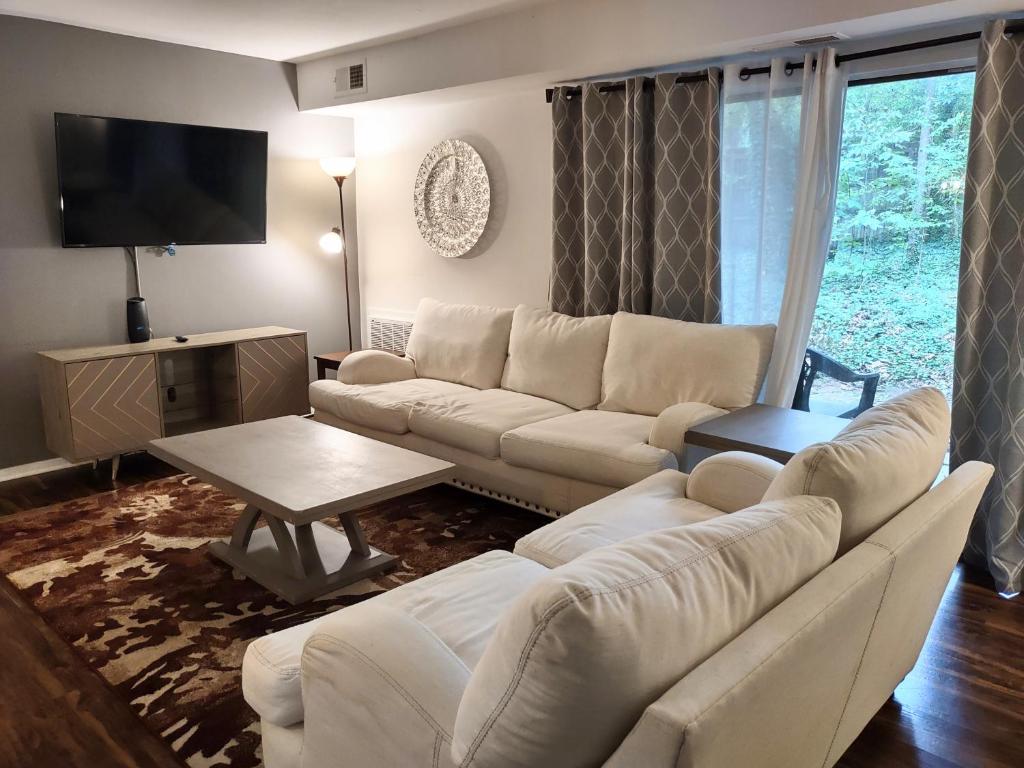 a living room with a white couch and a table at Charming Condo in Central Raleigh in Raleigh
