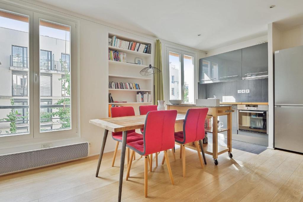 une cuisine avec une table en bois et des chaises rouges dans l'établissement Appartement Charenton - Welkeys, à Paris