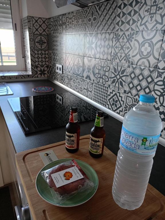 a bottle of water and two bottles of beer on a table at La Lunita in Valverde