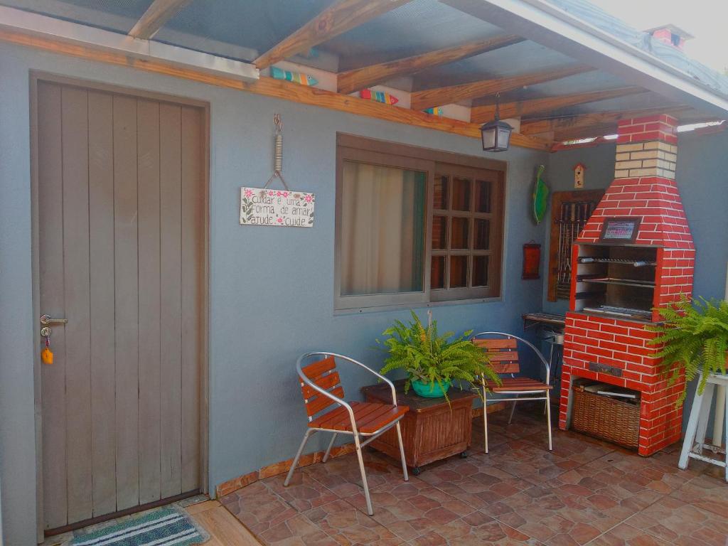 a patio with a brick fireplace and a table and chairs at Kitnet da Elô in Tramandaí