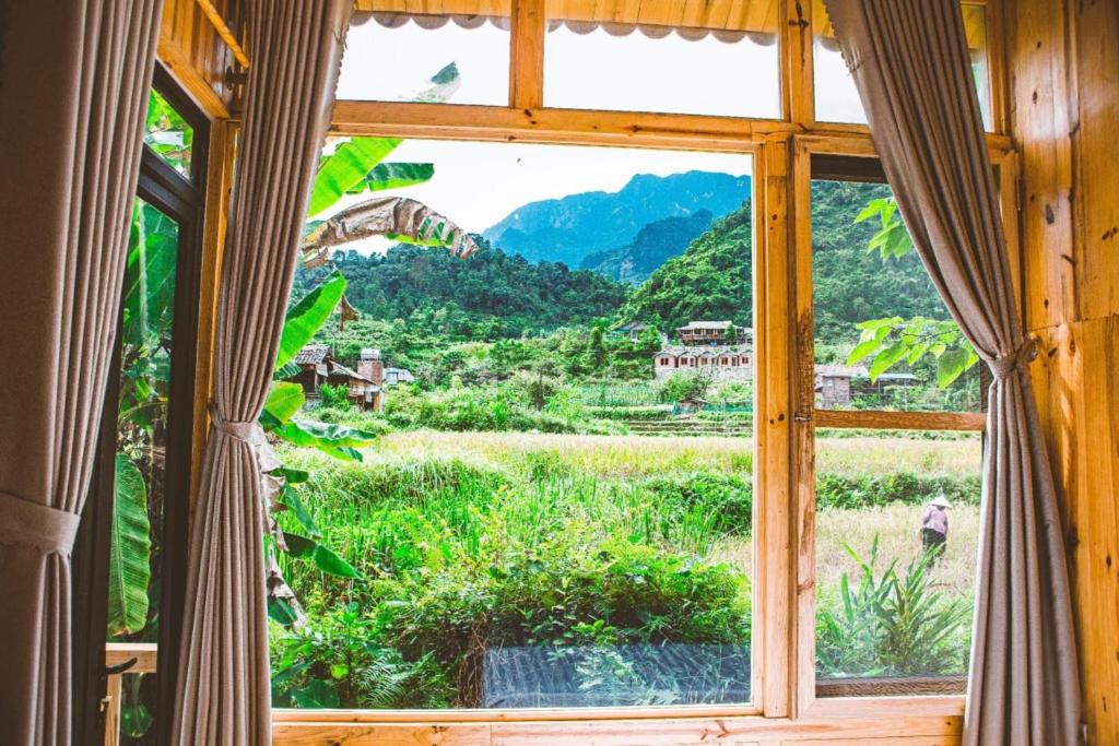 um quarto com uma janela com vista para um campo em Chien's Lodge Du Gia em Làng Cac