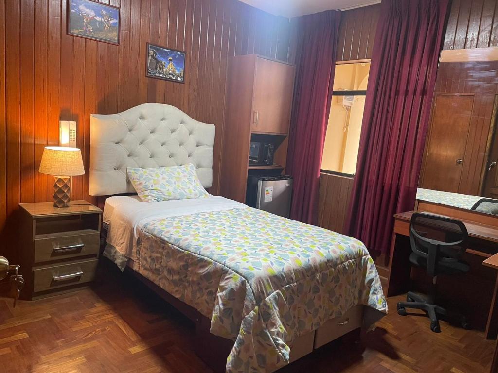 una camera con letto, scrivania e sedia di Habitación en Primer Piso con baño privado a Lima
