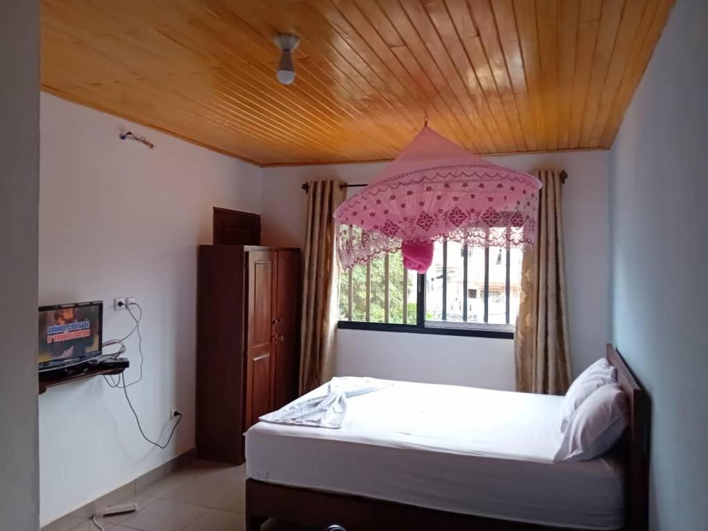 - une petite chambre avec un lit et une fenêtre dans l'établissement RÉSIDENCE TCHAMS, à Yaoundé
