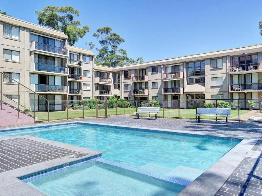 a swimming pool in front of a apartment building at The Poplars, Pool Access Getaway in Nelson Bay