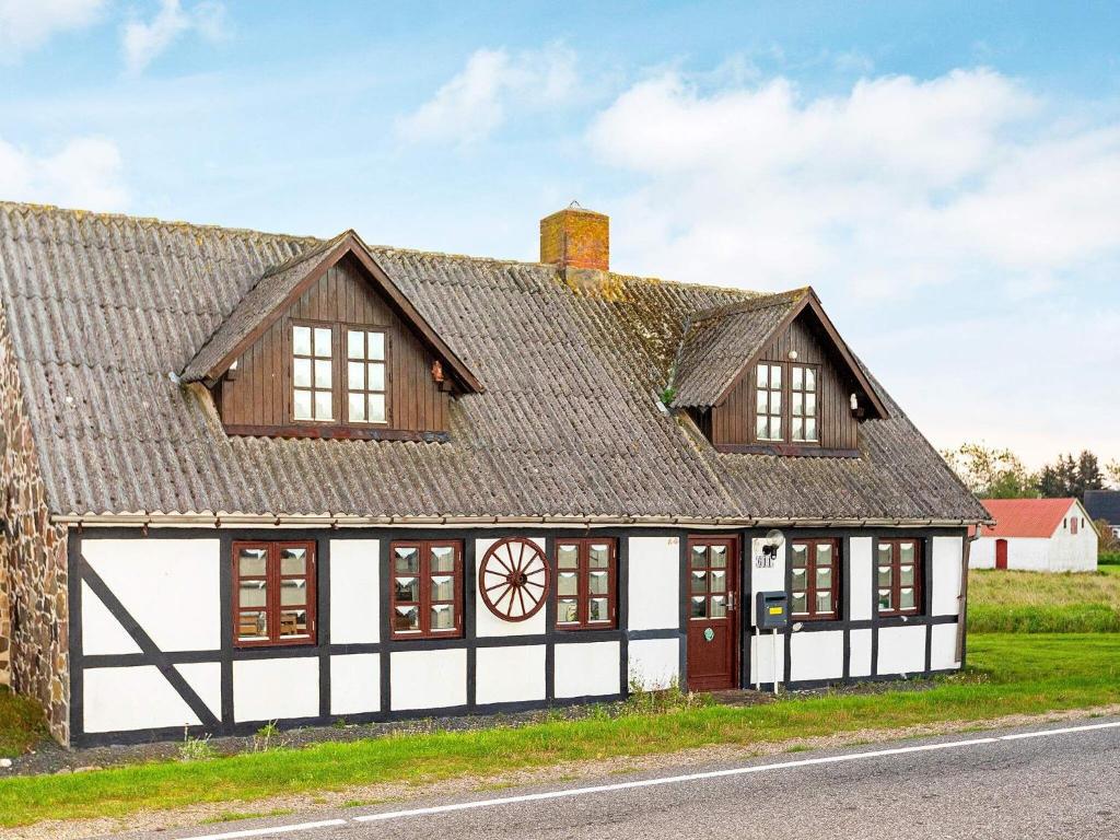 an old white and black building with a roof at Holiday home Løgstør IX in Løgstør