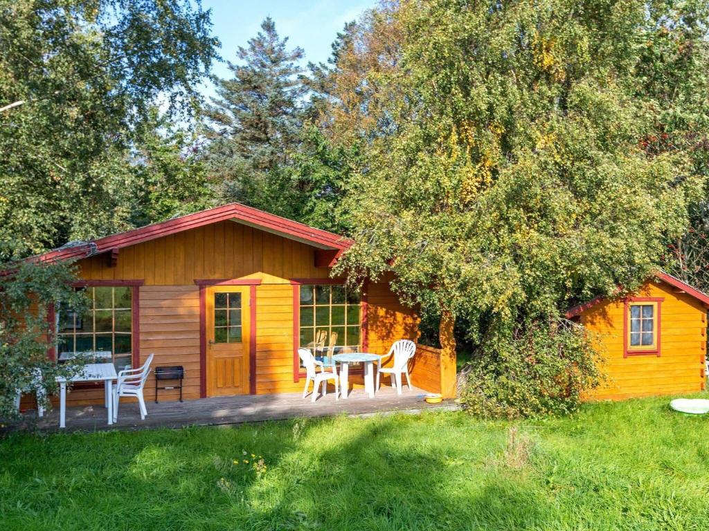 een hut met een tafel en stoelen op een terras bij Holiday home Farsø IX in Farsø