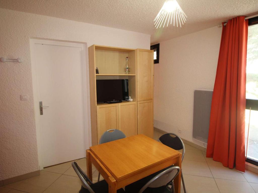 オリにあるAppartement Auris, 1 pièce, 3 personnes - FR-1-297-335のテーブルと椅子、テレビが備わる客室です。