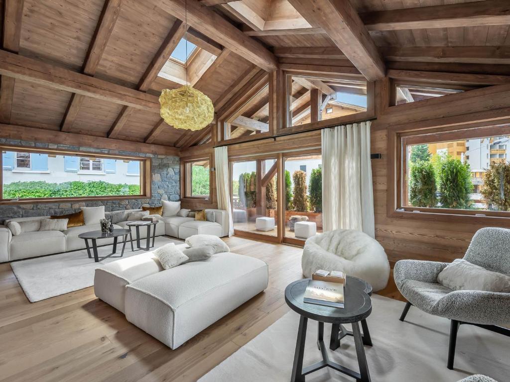 Elle comprend un salon doté d'un mobilier blanc et de plafonds en bois. dans l'établissement Chalet de luxe à 2 pas des pistes avec piscine, sauna et salle de sport - FR-1-569-134, à Megève