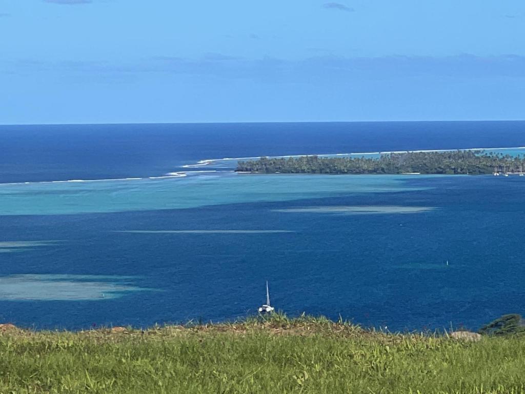 - une vue sur une grande étendue d'eau avec un bateau dans l'établissement La Suite Vue Lagon, à Uturoa