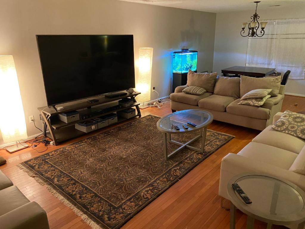 een woonkamer met een grote flatscreen-tv bij MedcapCt in Virginia Beach