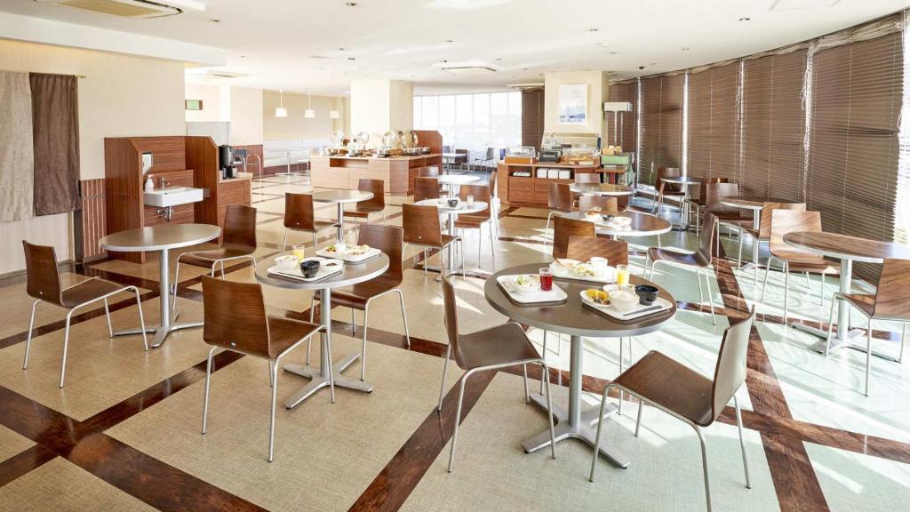 半田市にあるセンターワンホテル半田のテーブルと椅子が備わるレストラン
