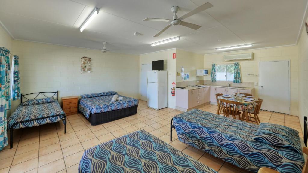 a room with two beds a table and a kitchen at Gone Fishin Holiday Units in Karumba