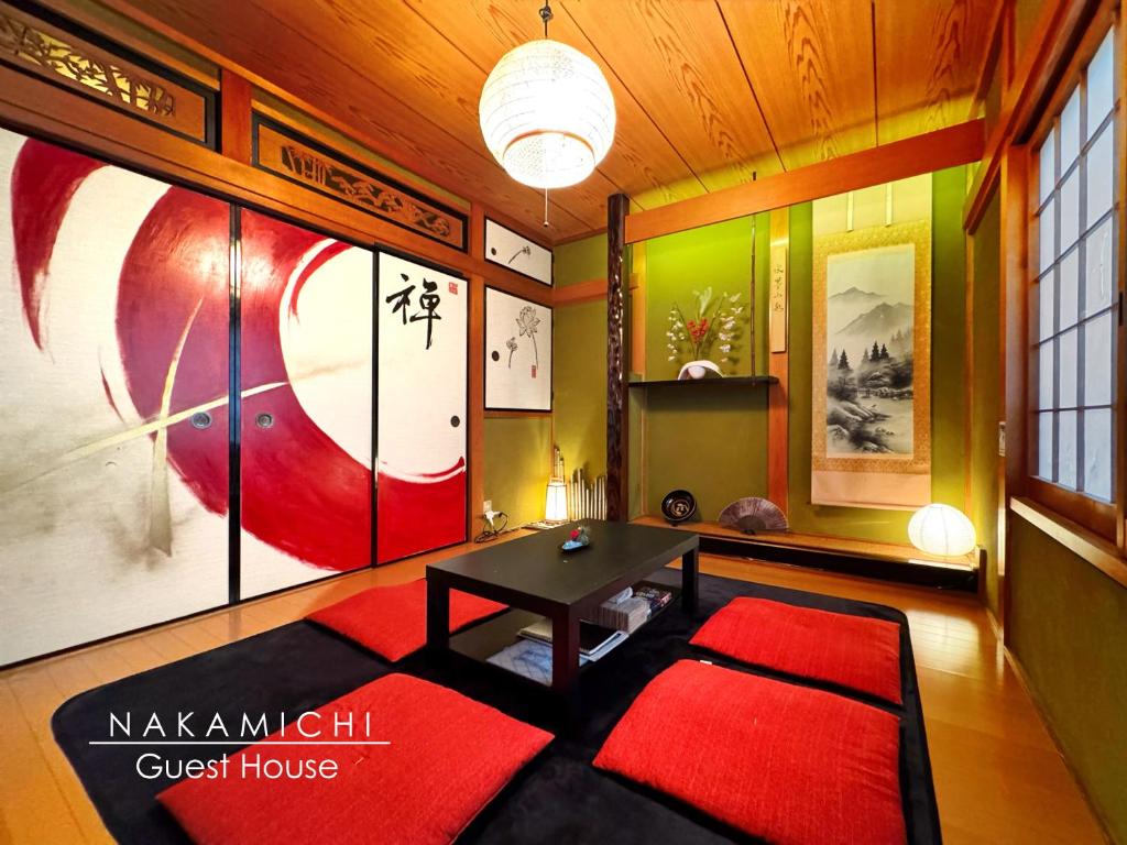 un soggiorno con tavolo e tappeto rosso di guesthouse中道 ad Osaka