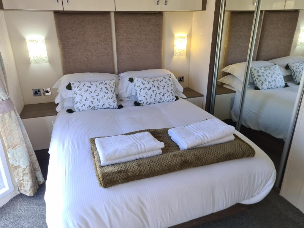 a bedroom with a large white bed with towels on it at Bock Retreat Lodge 54 with Hot Tub in Felton