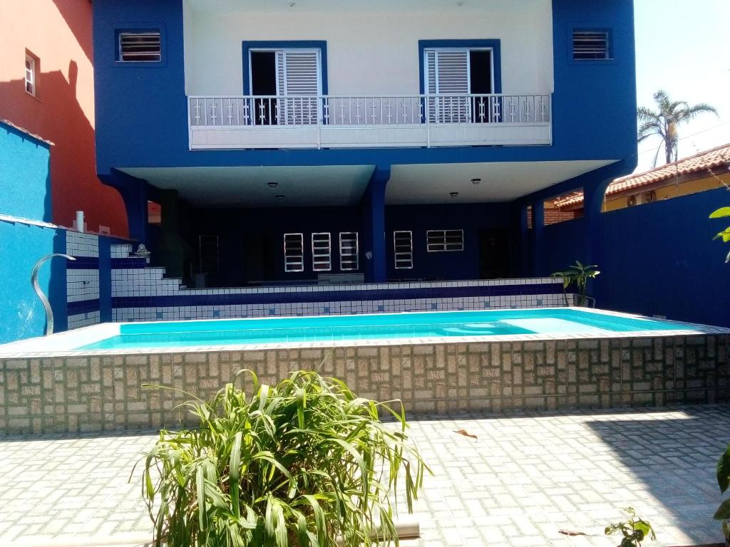 een huis met een zwembad ervoor bij Casa aconchegante de praia in Itanhaém