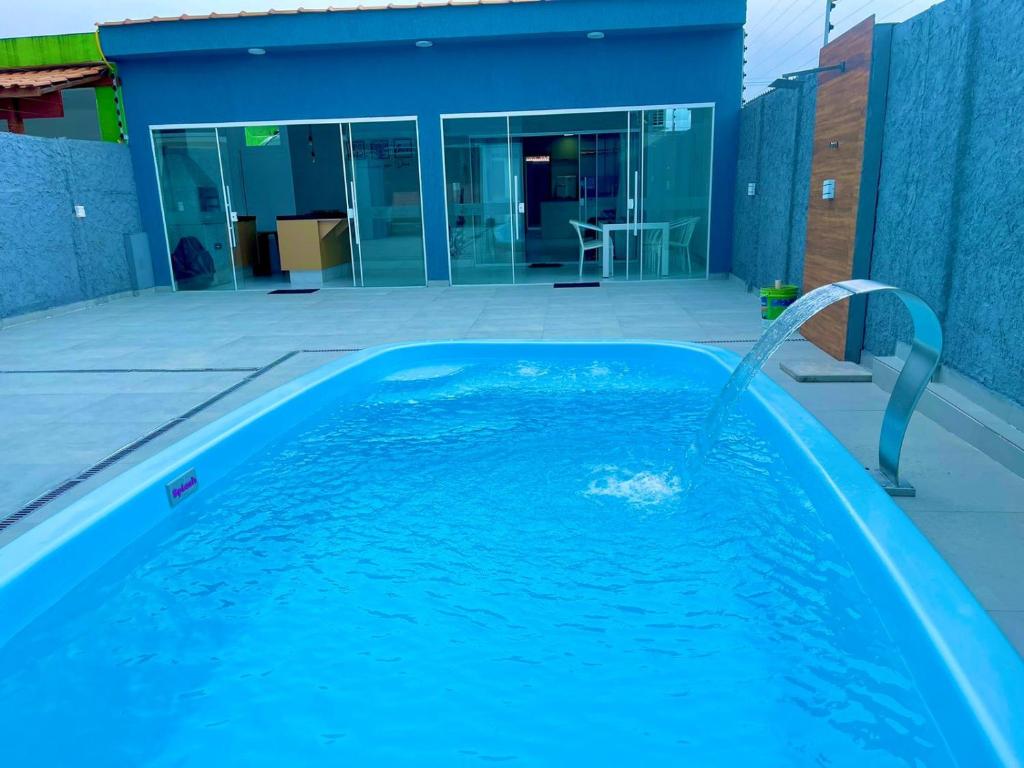 einem Pool mit einem Brunnen vor einem Gebäude in der Unterkunft Casa com piscina e hidromassagem praia Enseada. in Guarujá