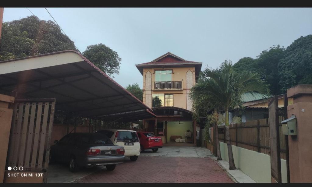 uma casa com dois carros estacionados numa garagem em ILHAMVILLA GUEST HOUSE Binjai Kubang Kerian 