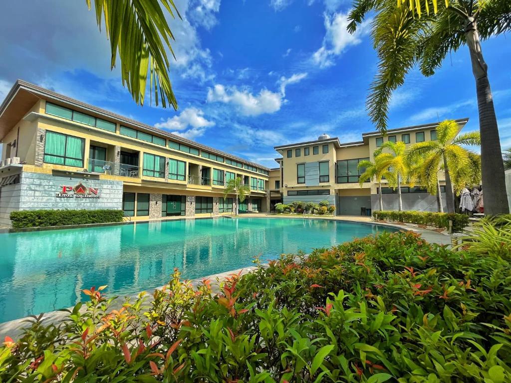 a swimming pool in front of a building at PAN HOTEL AND RESORT in Abucay