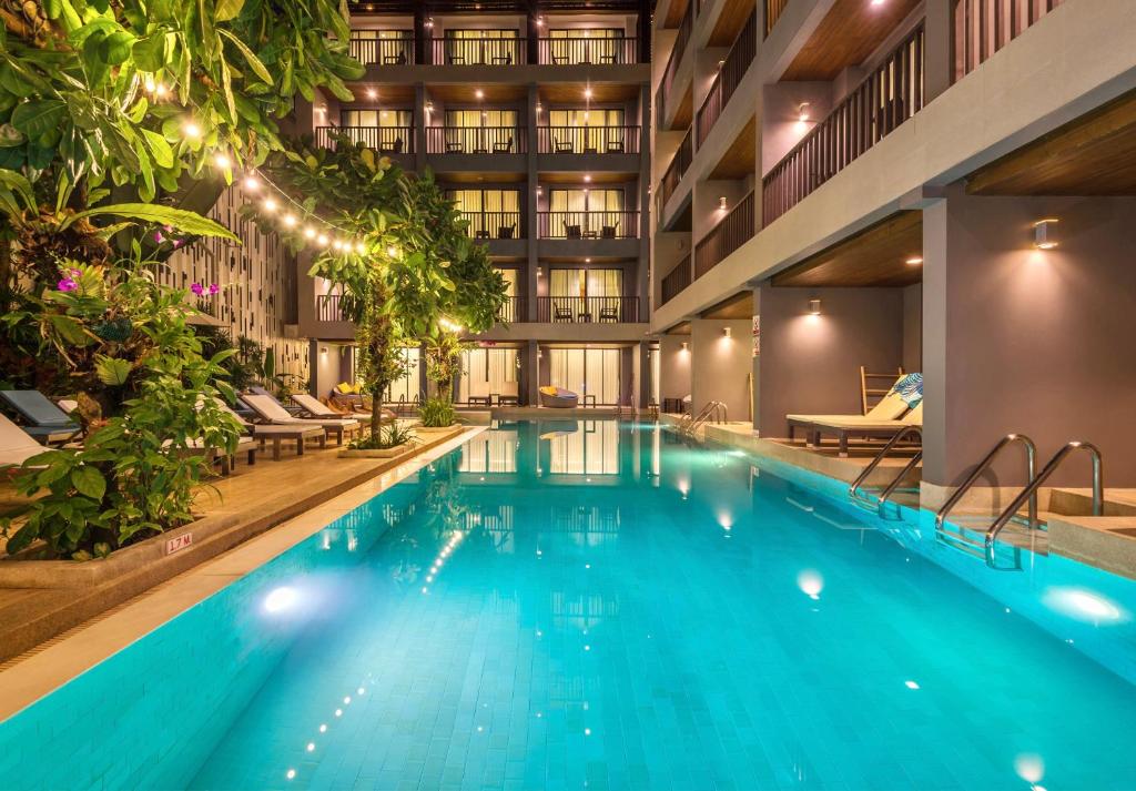 une grande piscine dans un bâtiment avec des plantes dans l'établissement Areetara Aonang Krabi, à Ao Nang Beach