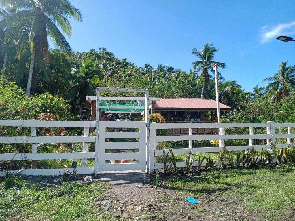 a white fence in front of a house at LABUYO FARM 