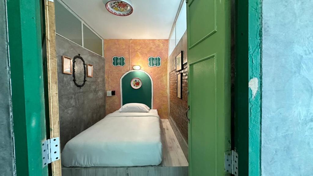 a small room with two beds and a green door at Fluid PHUKET in Ban Sam Kong