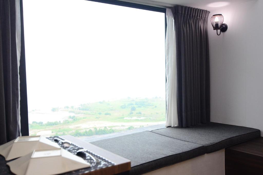 - un siège de fenêtre dans une chambre avec une grande fenêtre dans l'établissement Imperio Residence Melaka by Dream View, à Malacca