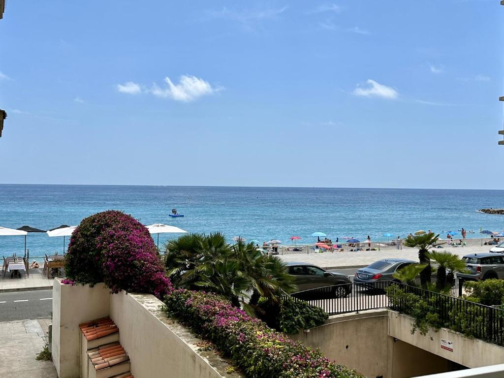 a view of the beach and the ocean from a balcony at Spacieux appartement face mer in Menton