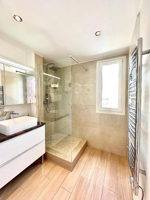 a bathroom with a sink and a glass shower at Chaleureux T4, à 20 min de Paris in Argenteuil