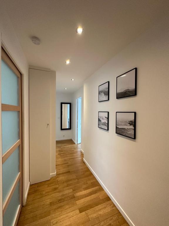 a hallway with four pictures on a wall at Chaleureux T4, à 20 min de Paris in Argenteuil