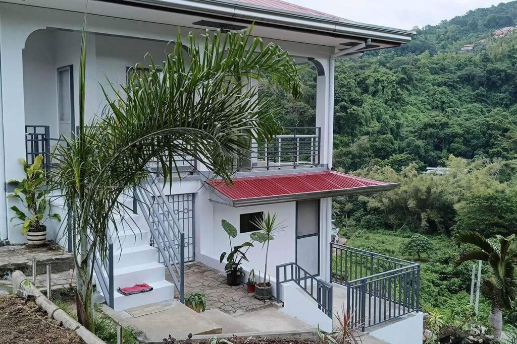 a house with a balcony with plants on it at Ocean and mountain view house in Mabini