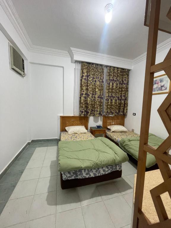 A cozy room in 2 bedrooms apartment with a back yard في شرم الشيخ: غرفة نوم بسريرين ونافذة