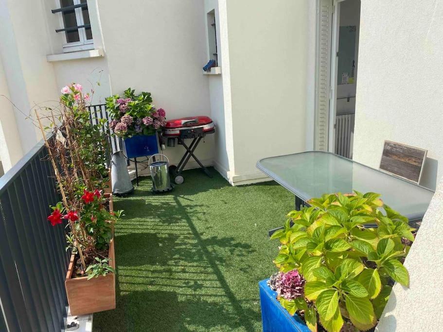 d'un balcon avec des plantes en pot et une table en verre. dans l'établissement Eiffel Beaugrenelle - Beautiful T2 58m2 with Terrasse 22m2, à Paris