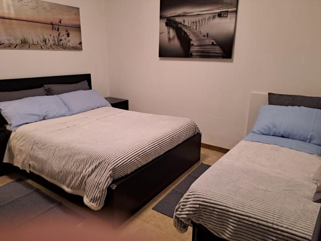 1 dormitorio con 2 camas y una foto en la pared en Da NONNA ROSA Camera Nera, en Budrio