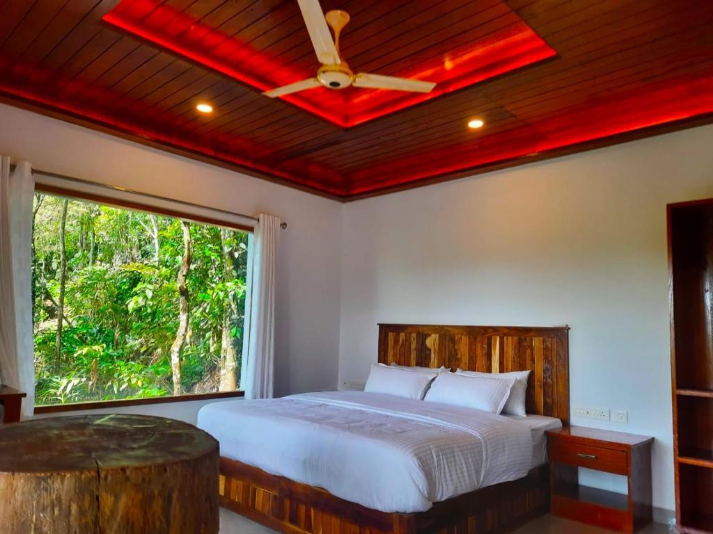 1 dormitorio con cama y ventana grande en kurinjiyil Farm Stay Munnar en Munnar