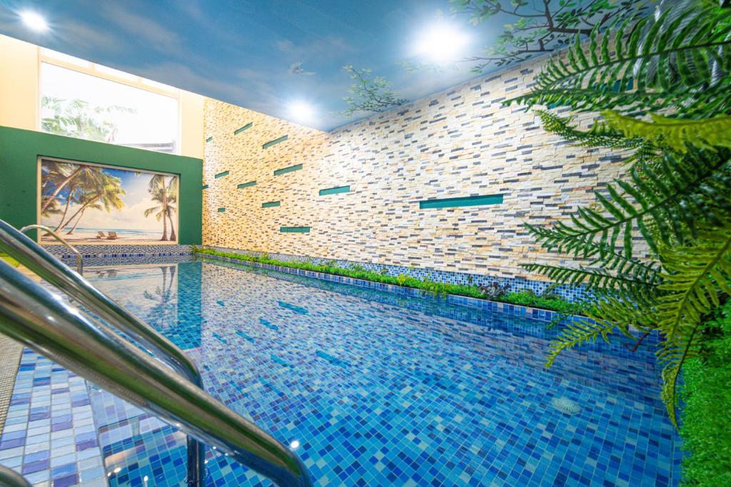 a swimming pool next to a brick wall at Golden Star Hotel by THG in Da Nang